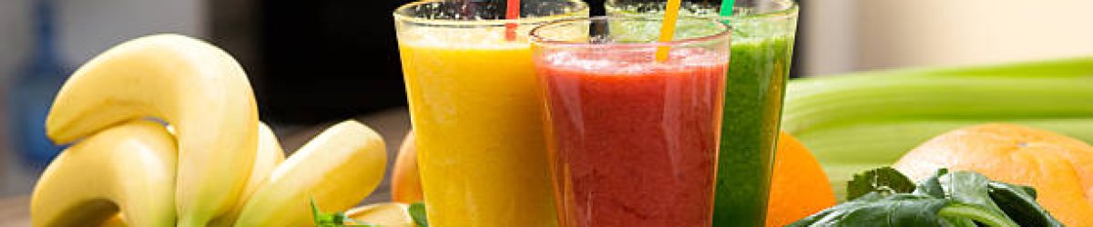 Fresh fruit and vegetable smoothie on kitchen table in glass